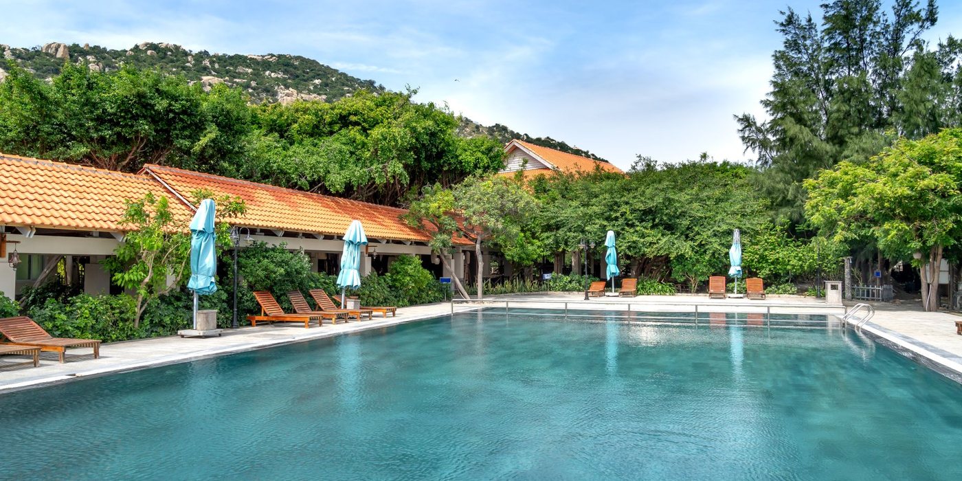 Quiet tropical resort pool surrounded by greenery